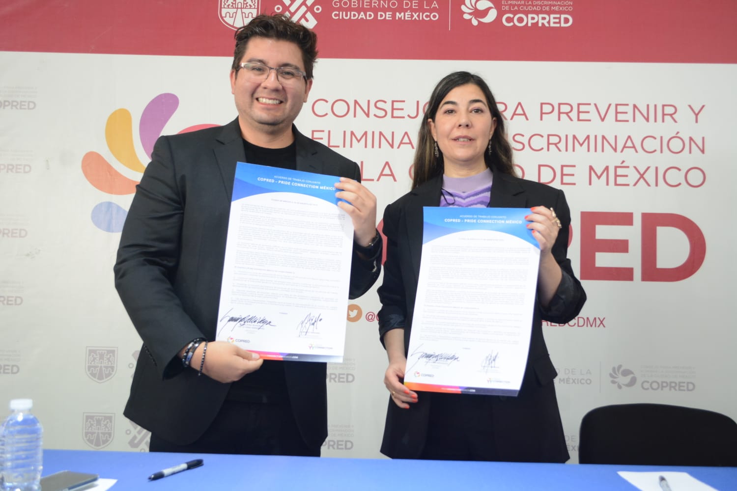 Foto de la titular de Copred, Geraldina González de la Vega y el Director General de Pride Connectio México sosteniendo el acuerdo firmado de trabajo.